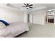 Spacious main bedroom with carpet, ceiling fan, tray ceiling, and bathroom access at 3426 Schoolhouse Rd, Harmony, FL 34773