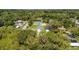 An aerial view of a home with lush surroundings and mature trees, showcasing the property's setting at 3678 Rollin O Ln, Apopka, FL 32703