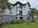 A well-maintained condo building with light blue walls, black trim, balconies, and lush green landscaping at 3724 Castle Pines Ln # 4234, Orlando, FL 32839