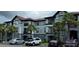 A spacious condo building featuring multiple units, balconies, and a parking area with several vehicles at 3724 Castle Pines Ln # 4234, Orlando, FL 32839