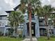 Attractive building exterior with palm trees, blue and white color scheme, balconies, and nicely landscaped grounds at 3724 Castle Pines Ln # 4234, Orlando, FL 32839