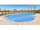Community swimming pool with lounge chairs, umbrellas, and palm trees on a sunny day at 471 Wayland Dr, Haines City, FL 33844