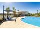 Community swimming pool features lounge seating, umbrellas, and mature palm trees at 471 Wayland Dr, Haines City, FL 33844