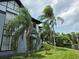 A view of a two-story condo building with a water view and swaying palm trees at 5501 Pga Blvd # 4723, Orlando, FL 32839