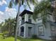 Exterior of a two-story condo featuring balconies and well-maintained landscaping with swaying palm trees at 5501 Pga Blvd # 4723, Orlando, FL 32839