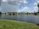 Scenic water view of condos, featuring the community's tranquil lake and lush landscaping at 5501 Pga Blvd # 4723, Orlando, FL 32839