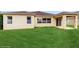 Back view of the house highlighting a large, green lawn and neutral color scheme at 579 Setting Sun Dr, Winter Garden, FL 34787