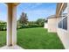 View of the spacious backyard featuring lush green grass and a well-maintained privacy hedge at 579 Setting Sun Dr, Winter Garden, FL 34787