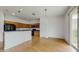 Open-concept kitchen with wood cabinets, black appliances, and wood floors, seamlessly connected to the dining area at 579 Setting Sun Dr, Winter Garden, FL 34787
