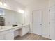 Bathroom with double sinks, vanity area, and white cabinets, plus wood-look flooring at 6112 Broad Oak Dr, Davenport, FL 33837