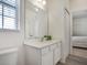 Bright bathroom offers a white vanity, ample mirror, and wood-look tile flooring for a spa-like feel at 6112 Broad Oak Dr, Davenport, FL 33837