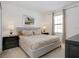 Comfortable bedroom with a tufted headboard bed, side tables, and a window with bright natural light at 6112 Broad Oak Dr, Davenport, FL 33837