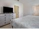 Comfortable main bedroom features a queen bed, dresser with TV, and ensuite bath access at 6112 Broad Oak Dr, Davenport, FL 33837