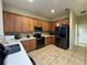 Kitchen featuring oak cabinets, quartz countertops, stainless steel appliances, and tile flooring at 6224 Zane Dr, Mount Dora, FL 32757