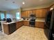 Kitchen with stainless steel appliances, oak cabinets and tile flooring at 6224 Zane Dr, Mount Dora, FL 32757