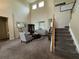 Open-concept living room featuring tall ceilings, carpet flooring, stairs, and ample natural light at 6224 Zane Dr, Mount Dora, FL 32757