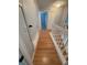 Upstairs hallway with wood-look flooring and white railing overlooking the stairs at 7727 Glynde Hill Dr, Orlando, FL 32835