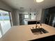 Open-concept kitchen with a large island, stainless steel appliances, and seamless flow to the living area at 7727 Glynde Hill Dr, Orlando, FL 32835