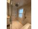 Modern shower featuring rainfall shower head, sleek tiling, and glass door at 7727 Glynde Hill Dr, Orlando, FL 32835