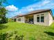 Backyard shows covered patio area with outdoor seating, grassy lawn, and home's back exterior at 8047 Chilton Dr, Orlando, FL 32836