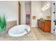 Bright bathroom featuring a soaking tub, a vanity with granite countertop, and a view to the closet at 8047 Chilton Dr, Orlando, FL 32836