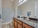 Bright bathroom with a shower/tub, granite countertop and lovely decorative shower curtain at 8047 Chilton Dr, Orlando, FL 32836