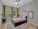 Bedroom featuring a ceiling fan, a polka dot accent wall and plenty of natural light from a large window at 8047 Chilton Dr, Orlando, FL 32836