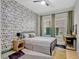 Bedroom featuring a ceiling fan, a book-themed accent wall and plenty of natural light from a large window at 8047 Chilton Dr, Orlando, FL 32836