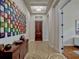 Inviting home hallway with colorful wall art, light hardwood floors, and a decorative rug creating a warm entrance at 8047 Chilton Dr, Orlando, FL 32836
