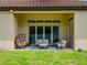 Covered patio has outdoor seating on blue patterned rug, sliding glass doors, and a view of the grassy yard at 8047 Chilton Dr, Orlando, FL 32836