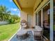 Covered patio area has outdoor seating with blue patterned rug, door to yard, and sliding glass doors to interior at 8047 Chilton Dr, Orlando, FL 32836