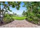 Beautiful backyard features a lush green lawn and serene lake view, framed by mature trees and landscaping at 8473 Granada Blvd, Orlando, FL 32836