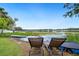 Lakefront property featuring a serene view of water and lounge chairs at waters edge for outdoor relaxation at 8473 Granada Blvd, Orlando, FL 32836