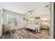 Cozy bedroom features a ceiling fan, wood floors, and a comfortable sitting chair near a window at 8473 Granada Blvd, Orlando, FL 32836