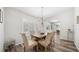 Bright dining room features wood floors, plantation shutters, and a stylish chandelier above the wood dining table at 8473 Granada Blvd, Orlando, FL 32836