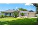Charming home with a manicured lawn, mature trees, and a welcoming entrance, perfect for curb appeal at 8473 Granada Blvd, Orlando, FL 32836