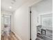 Hallway features hardwood floors and white walls, leading to a bedroom with natural light at 8473 Granada Blvd, Orlando, FL 32836