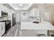 Modern kitchen featuring white cabinetry, stainless steel appliances, and a breakfast bar with quartz countertops at 8473 Granada Blvd, Orlando, FL 32836
