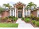 Elegant home entrance featuring a double door entry, columns and lush tropical landscaping at 8704 Ingleton Ct, Orlando, FL 32836
