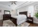 A main bedroom with a dark wood bed frame, and a neutral toned area rug on hardwood floors at 8704 Ingleton Ct, Orlando, FL 32836