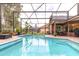 Large screened-in pool with tile accents, surrounded by lush landscaping and backyard views at 8704 Ingleton Ct, Orlando, FL 32836