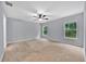 Large bedroom features two windows, ceiling fan and neutral carpeting and paint at 907 Pearly Ridge Ln, Lakeland, FL 33809