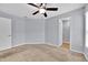 Spacious bedroom with a ceiling fan and an ensuite bathroom featuring neutral carpeting and paint at 907 Pearly Ridge Ln, Lakeland, FL 33809