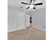 Neutral bedroom features a ceiling fan, closet, neutral walls, carpeting and an open doorway to the living area at 907 Pearly Ridge Ln, Lakeland, FL 33809
