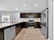 Bright kitchen showcases stainless steel appliances, wood cabinets, and luxury vinyl plank flooring at 907 Pearly Ridge Ln, Lakeland, FL 33809