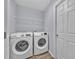 Convenient laundry room equipped with a modern washer, dryer, and storage shelves at 907 Pearly Ridge Ln, Lakeland, FL 33809