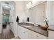 Bathroom with granite countertops, a mirror and white cabinets and access to the bedroom at 9426 Burnam Dr, Weeki Wachee, FL 34613