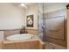A modern bathroom featuring a soaking tub, glass enclosed shower, and neutral tiling at 9426 Burnam Dr, Weeki Wachee, FL 34613