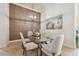 Stylish dining room with panel wall, glass table, modern lighting and elegant chairs at 9426 Burnam Dr, Weeki Wachee, FL 34613