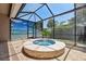 Enclosed lanai with a jacuzzi tub, tile flooring, and a screen wall for privacy and relaxation at 9426 Burnam Dr, Weeki Wachee, FL 34613